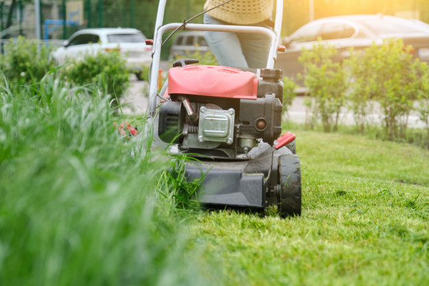 lawn-mower-cutting-green-grass-gardener-with-lawnmower-working_116407-35